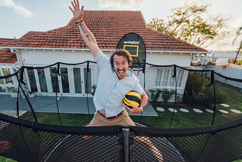 a man with a ball jumping inside a trampoline