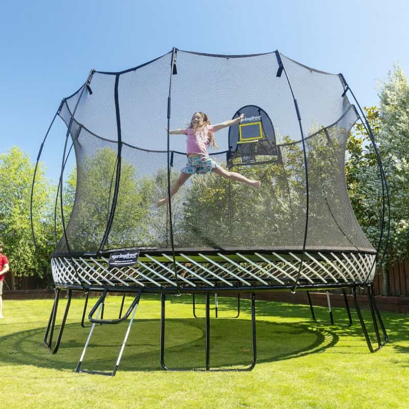 A girl jumping in mid-air on a Springfree Trampoline.