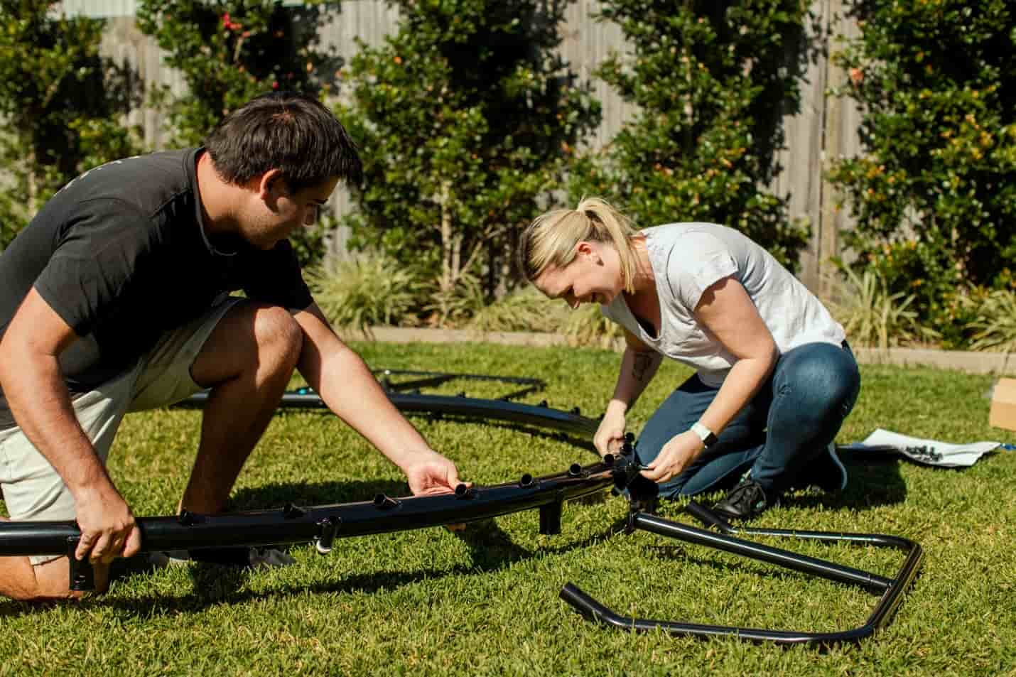 Two people installing a Springfree Trampoline.