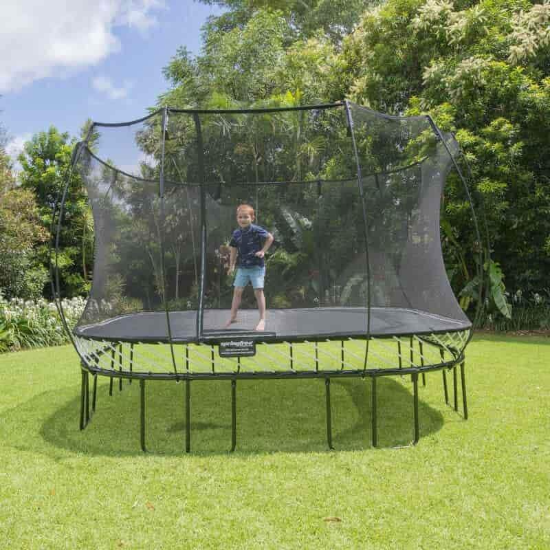 A kid jumping on a Springfree Large Square Trampoline. 