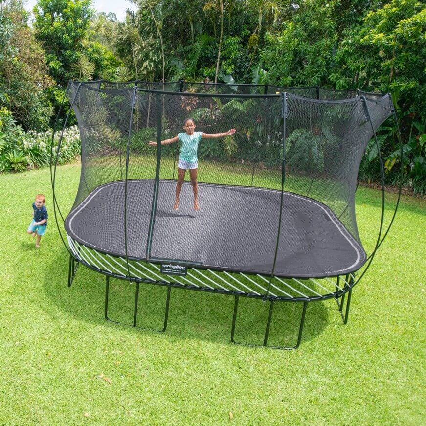 A kid jumping on a Springfree Square Trampoline.