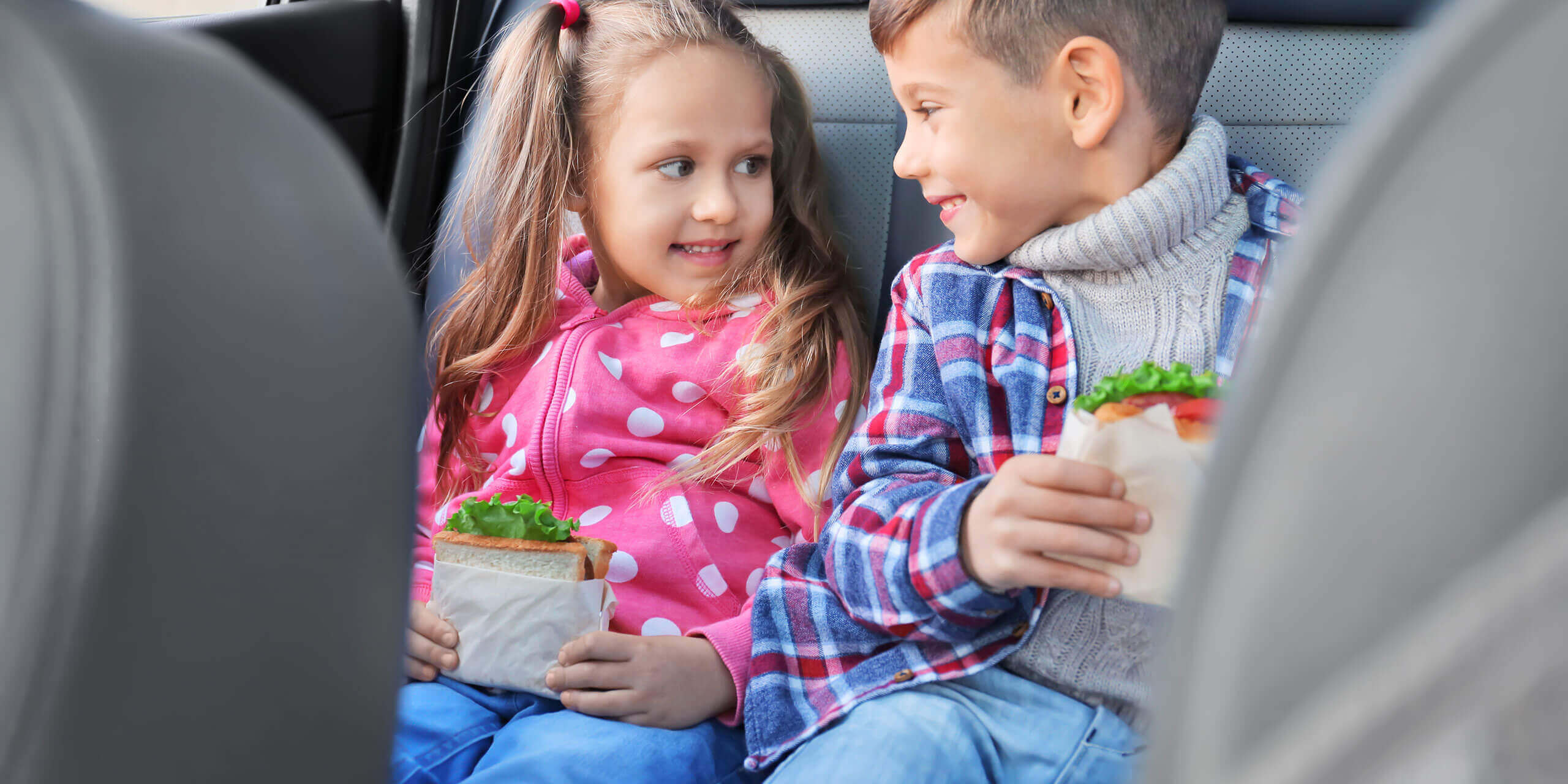 kids eating snacks inside a car