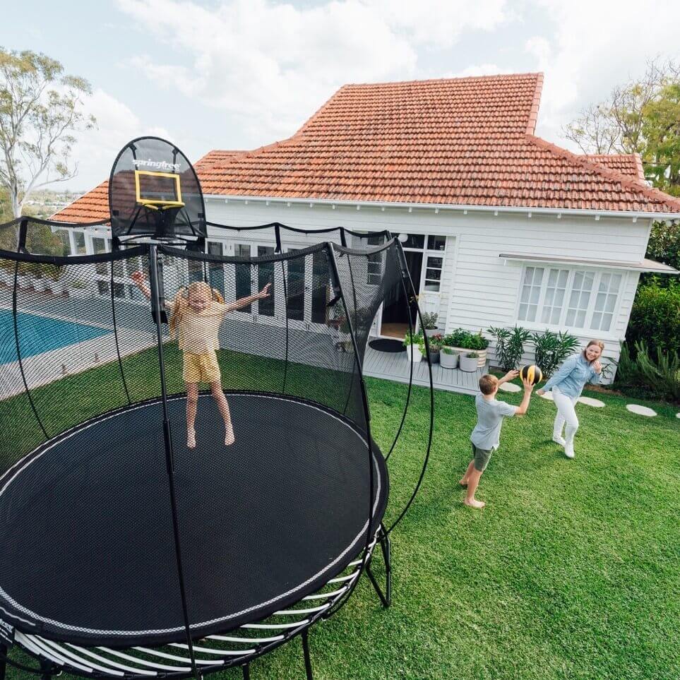 A girl jumping on a Springfree Round Trampoline. 