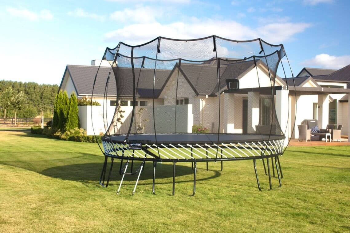 A Springfree Large Oval Trampoline in a backyard.