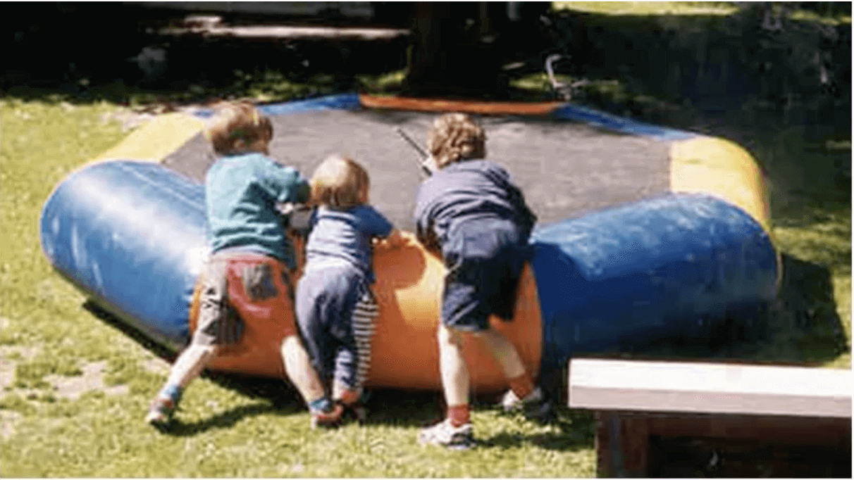 Three children on the first Springfree Trampoline prototype