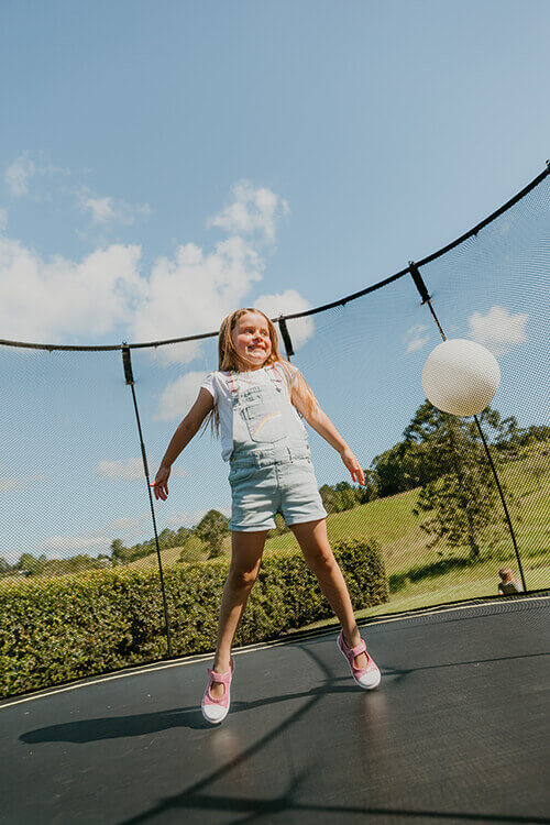 girl playing with balloon in springfree trampoline