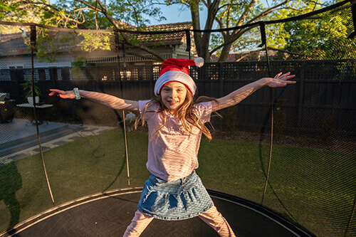 girl wearing santa hat inside the trampoline