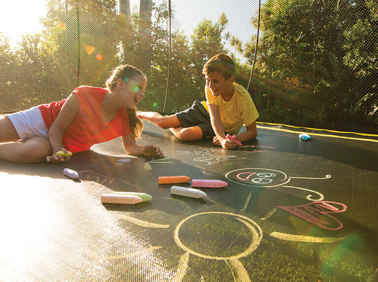 two kids drawing in a trampoline