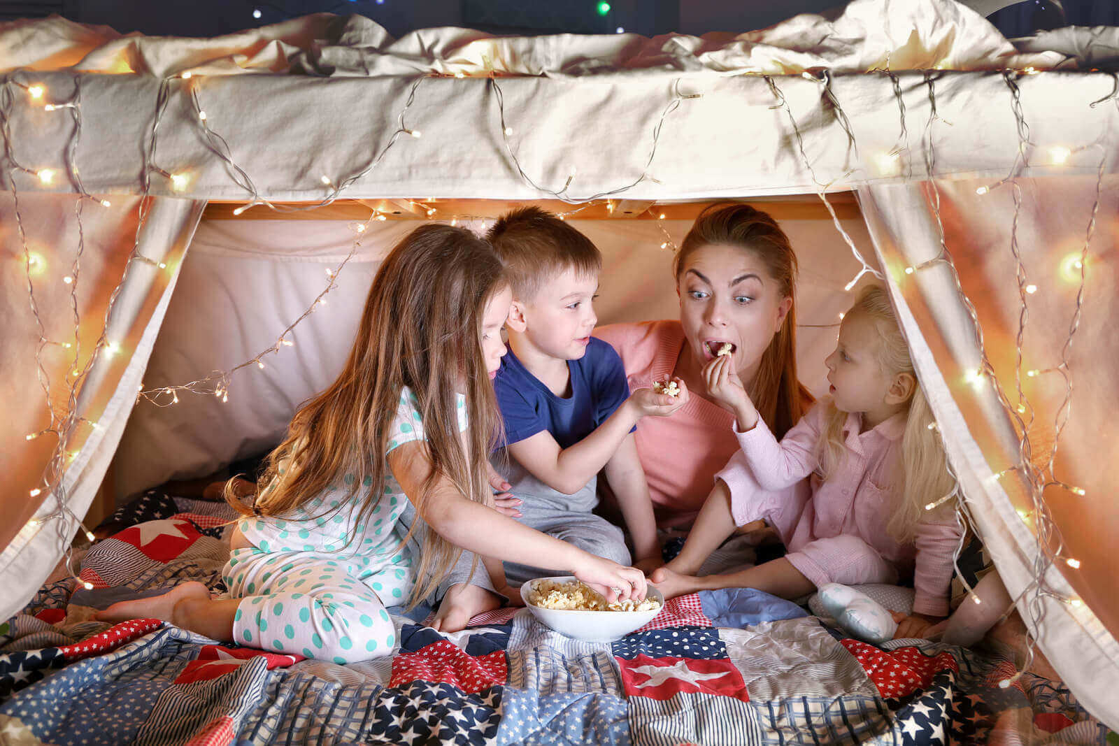 mother and kids eating popcorn in a trampoline