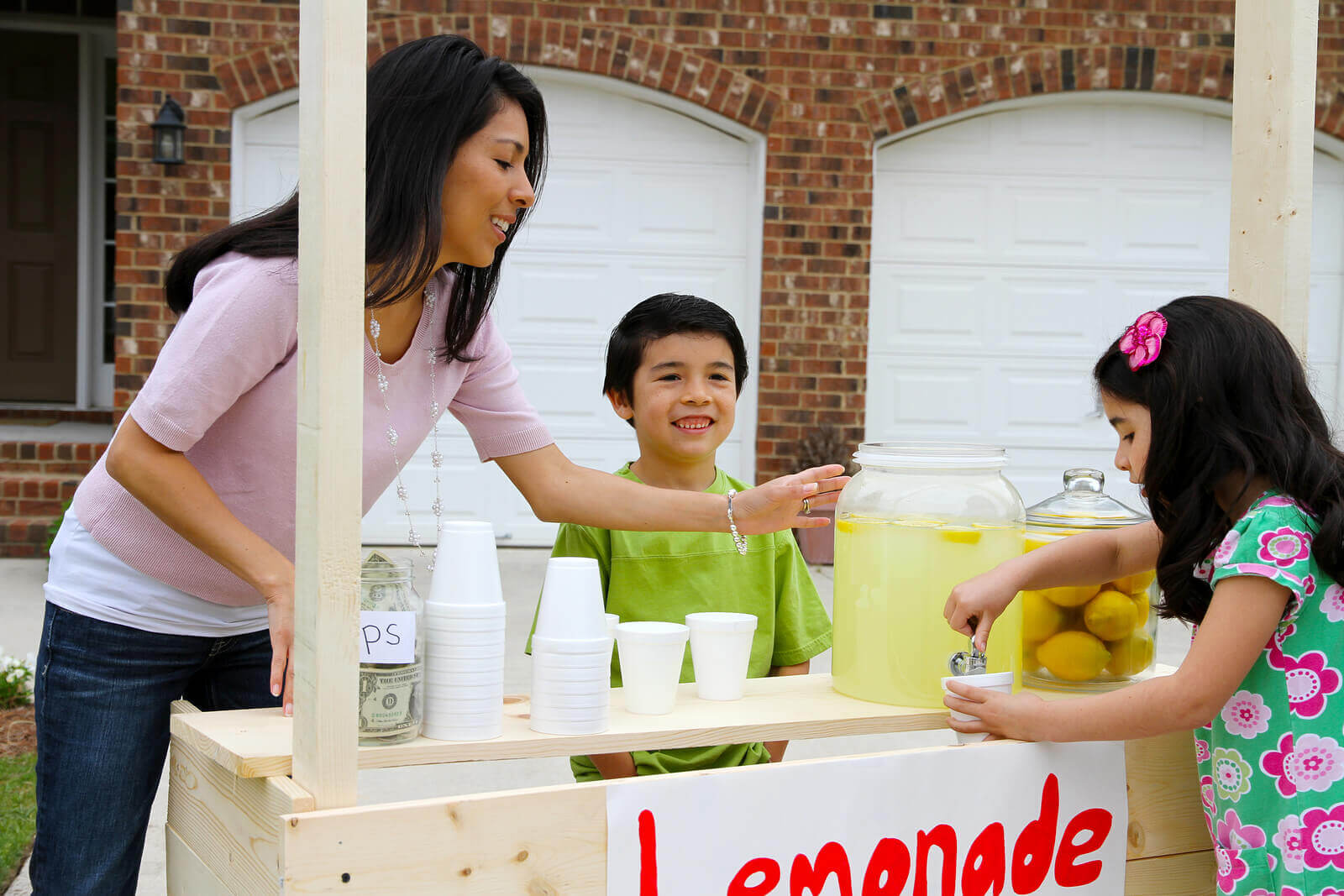 a woman with two kids in a lemonade stand