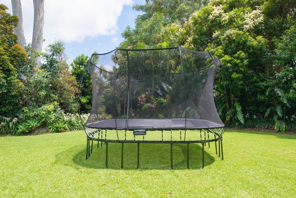 A Springfree Trampoline in a yard on a sunny day