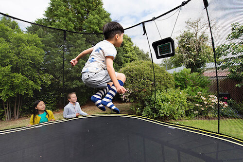 kid jumping while watching in a springfree trampoline