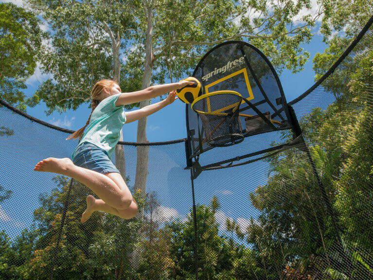girl shooting a ball in a ring inside the trampoline