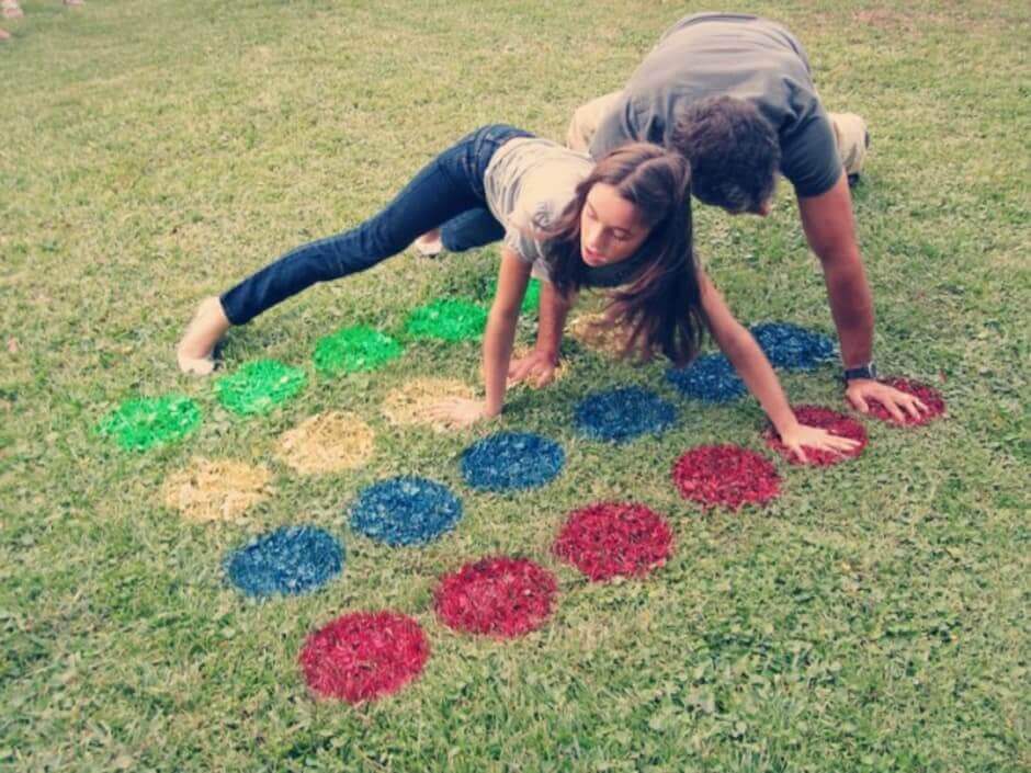 two person playing twister on the lawn in the backyard