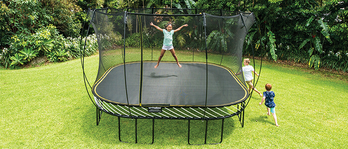 a kid jumping in a square trampoline